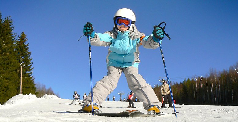 Ett barn på skidor i slalombacken