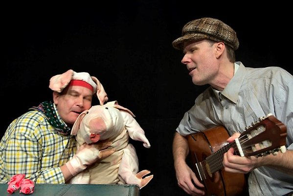 En skådespelare med en mjuk gris och en musiker med gitarr