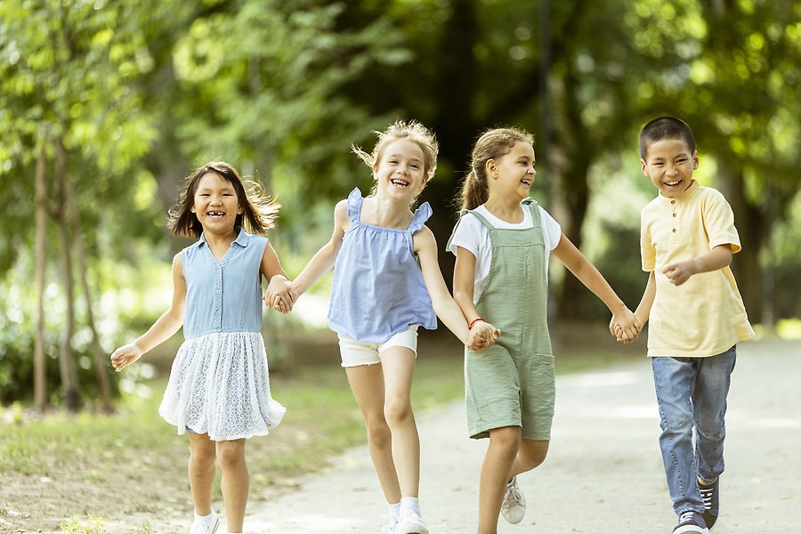 Barn springer tillsammans i sommarmiljö.